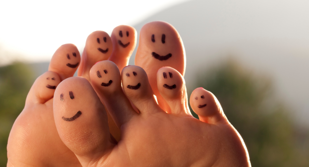 Feet that have smiley faces on each toe