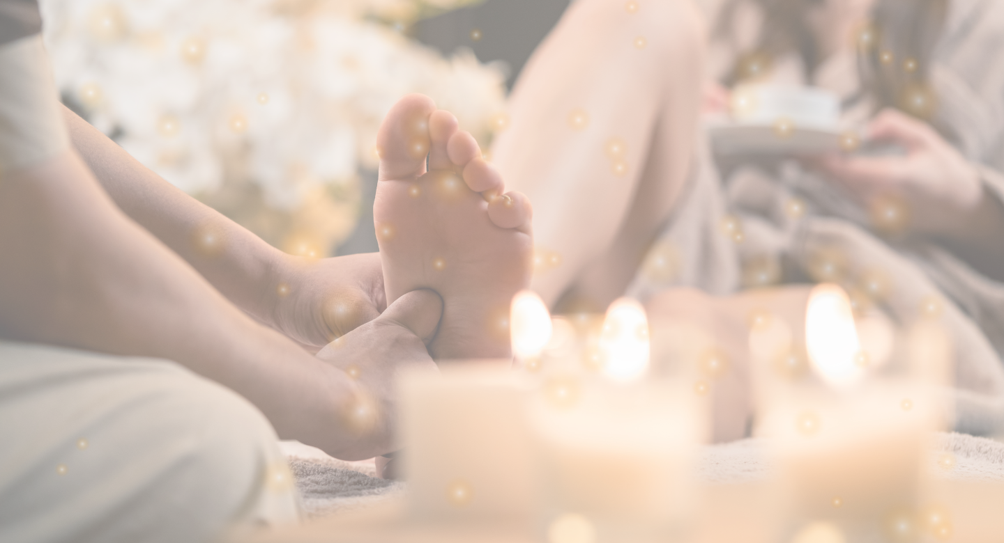 candles with person giving reflexology to a women's foot